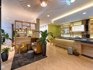 a restaurant with a potted plant in a room at Ibis Styles Aschaffenburg in Aschaffenburg