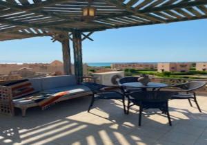 a patio with a couch and a table and chairs at Luxury Chalet - La Hacienda in Ras Sedr