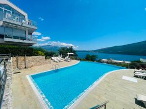 a swimming pool in a villa with a view of the water at Acacia Hills D8 in Herceg Novi in Herceg-Novi