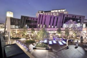 a large building with a courtyard in front of it at Place At Menlyn in Pretoria