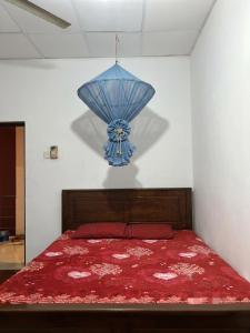 a bedroom with a bed with a blue chandelier at Freedom Rest Rooms in Anuradhapura