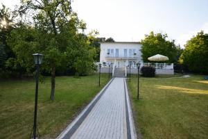a brick walkway in front of a white house at Ewilla- apartamenty Wojcieszyce in Wojcieszyce