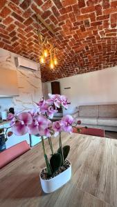 a vase with pink flowers sitting on a table at Il Grappolo in Gattinara