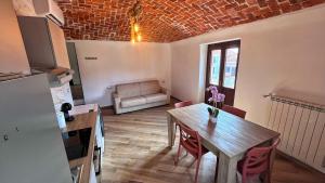 a kitchen and dining room with a table and a couch at Il Grappolo in Gattinara