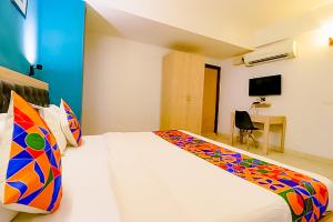 a bedroom with a large white bed with colorful pillows at Hotel Goldwind stay - Near Karkardooma Metro in New Delhi