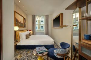 a hotel room with a bed and a chair at The Cura Hotel Kensington, London, a Tribute Portfolio Hotel in London +49 photos