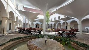 a fountain in a courtyard with tables and chairs at Bildungshaus Schloss Retzhof in Wagna