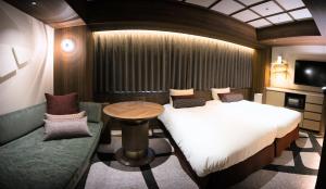 a bedroom with a bed and a table and a tv at Hotel Keihan Asakusa in Tokyo