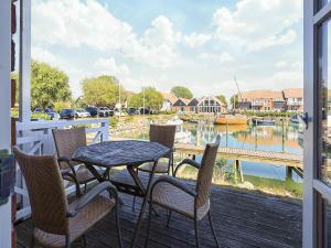 a table and chairs on a porch with a view of a marina at Møn - Klintholm Harbour in Borre