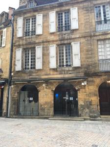an old brick building with two entrances with gates at L'instant Sarladais in Sarlat-la-Canéda