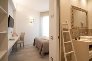 a small room with a bed and a mirror at Riviera Hotel in Senigallia +36 photos