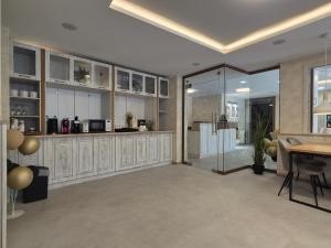 a kitchen with white cabinets and a table and a counter at Tarnovka - Guest Rooms in Veliko Tŭrnovo