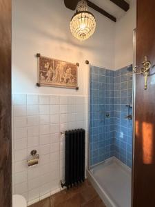 a bathroom with a chandelier and a blue and white shower at Villa Amore Tuscany in Capannori