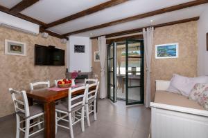 a kitchen and dining room with a table and chairs at Holiday House - Old Olive in Porozina