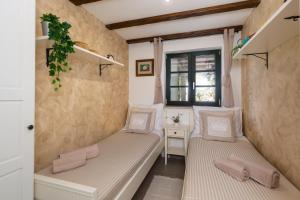 a room with two beds and a window at Holiday House - Old Olive in Porozina +29 photos