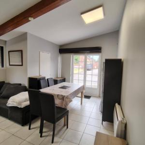 a living room with a table and chairs and a couch at L’Adresse 262  +5 photos