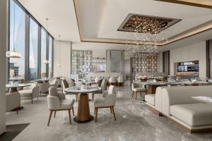 a restaurant with tables and chairs and windows at AC Hotel by Marriott Manila in Manila