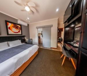 a bedroom with a bed and a desk with a sink at Nelspruit Lodge in Nelspruit