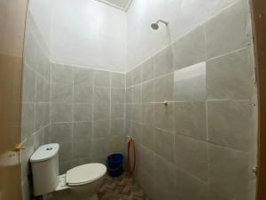 a bathroom with a toilet and a tiled wall at Chalet Gunung Stong in Dabung