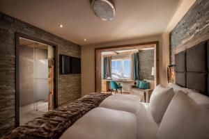 a hotel room with a large bed and a bathroom at Kesselspitze Hotel & Chalet, Valamar Collection - 4 Star Superior in Obertauern