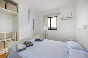 a white bedroom with a bed with towels on it at Sa Vinya d'Es Trenc in Campos +25 photos