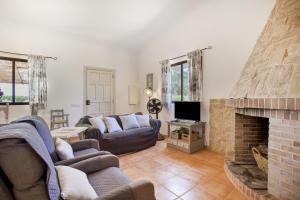 a living room with couches and a brick fireplace at Sa Vinya d'Es Trenc in Campos