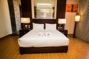 a bedroom with a large bed with two night stands at هوتيل بوسيك - Bosque Hotel in Hurghada +1 photo