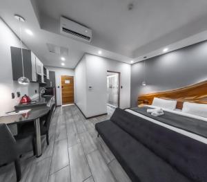 a bedroom with a large bed and a kitchen at Nelspruit Lodge in Nelspruit