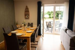 a dining room with a wooden table and chairs at Haus Figaro mit Hund in Wangerland