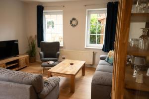 a living room with two couches and a coffee table at Haus Figaro mit Hund in Wangerland