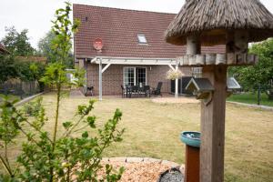 a bird house in the yard of a house at Haus Figaro mit Hund in Wangerland