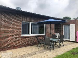 a table and chairs with an umbrella in front of a brick house at Haus Horst in Schillig