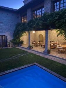 a backyard with a blue pool in front of a house at Etxauri Palace for art lovers in Echauri
