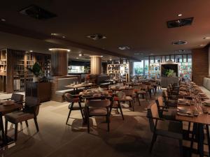 a restaurant with tables and chairs and a fireplace at Novotel Perth Murray Street in Perth