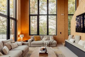 a living room with two couches and large windows at Les Terrasses de Durbuy in Durbuy