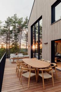 a wooden deck with a wooden table and chairs at Les Terrasses de Durbuy in Durbuy