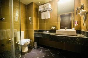 a bathroom with a toilet and a sink and a mirror at هوتيل بوسيك - Bosque Hotel in Hurghada