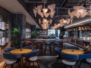 a restaurant with tables and chairs and a bar at Mercure Kyoto Station in Kyoto
