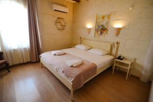 a bedroom with a bed with two towels on it at Cappadocia Mihran Sultan in Avanos +2 photos
