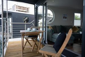 a living room with a table and a couch at Hausboot Kajüte am Nixensteg Am Wangermeer mit Hund in Wangerland