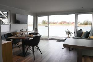 a living room with a table and a couch at Hausboot Kajüte am Nixensteg Am Wangermeer mit Hund in Wangerland +15 photos