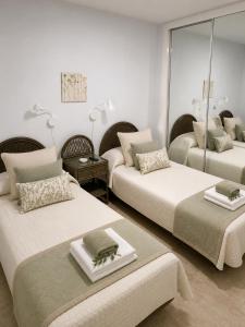a bedroom with two beds and a mirror at Albaricoques Sun & Beach in Maspalomas