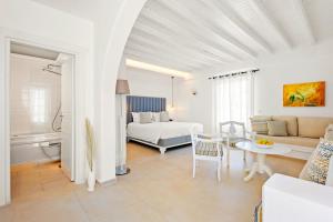 a white room with a bed and a couch at San Marco Hotel and Villas in Houlakia