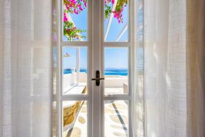 an open door with a view of the beach at San Marco Hotel and Villas in Houlakia