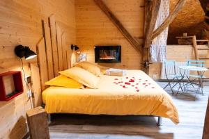 a bedroom with a bed in a log cabin at Maison D'hôtes et Spa La Boucotte in Vellerot-lès-Vercel