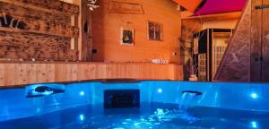 a blue tub in a room with a fireplace at Maison D'hôtes et Spa La Boucotte in Vellerot-lès-Vercel