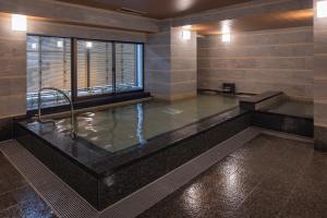 a large bathroom with a tub with a window at Hotel New Green Plaza in Nagaoka