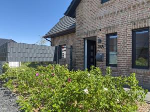 a brick house with a bush in front of it at Haus Strandhafer in Wangerland