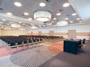 a large room with rows of tables and chairs at Mövenpick Hotel Amsterdam City Centre in Amsterdam