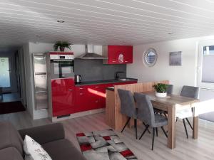 a kitchen with red cabinets and a wooden table at Hausboot Optima in Wangerland